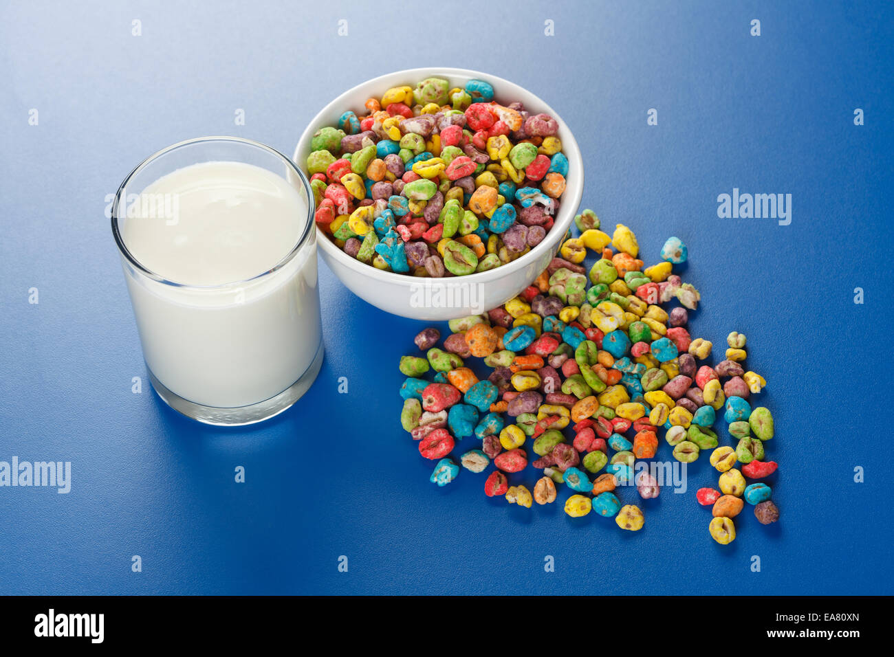 Cibo malsano: schioccato in semi di grano con un sacco di colorante artificiale e bicchiere di latte Foto Stock