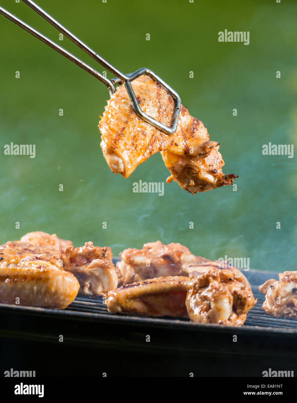 Ali di pollo su barbecue grill con il fuoco Foto Stock