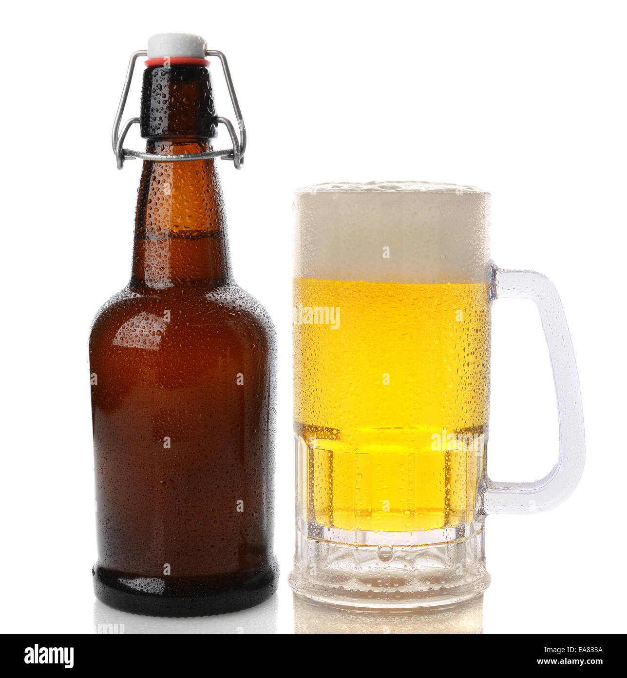 Primo piano di una tazza di birra con una testa di schiumato accanto a una swing top brown bottiglia di birra. Dritto sparato su uno sfondo bianco con r Foto Stock