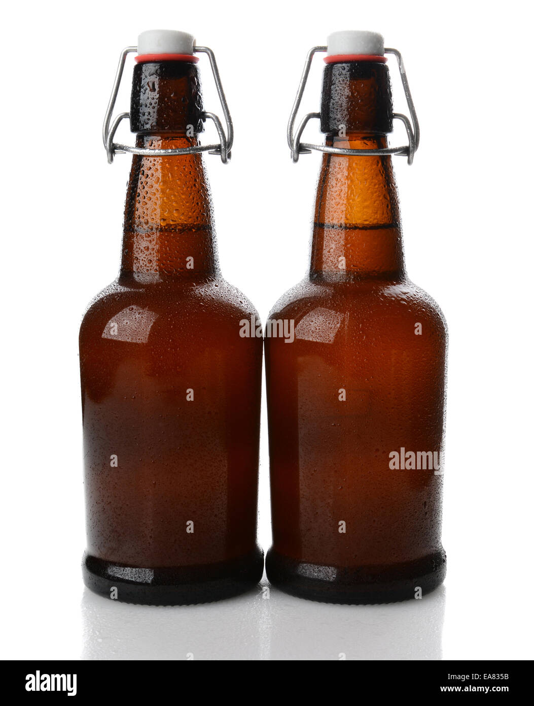 Primo piano di due cold swing top marrone a bottiglie di birra coperti con condensazione. Formato verticale su bianco con la riflessione. Foto Stock