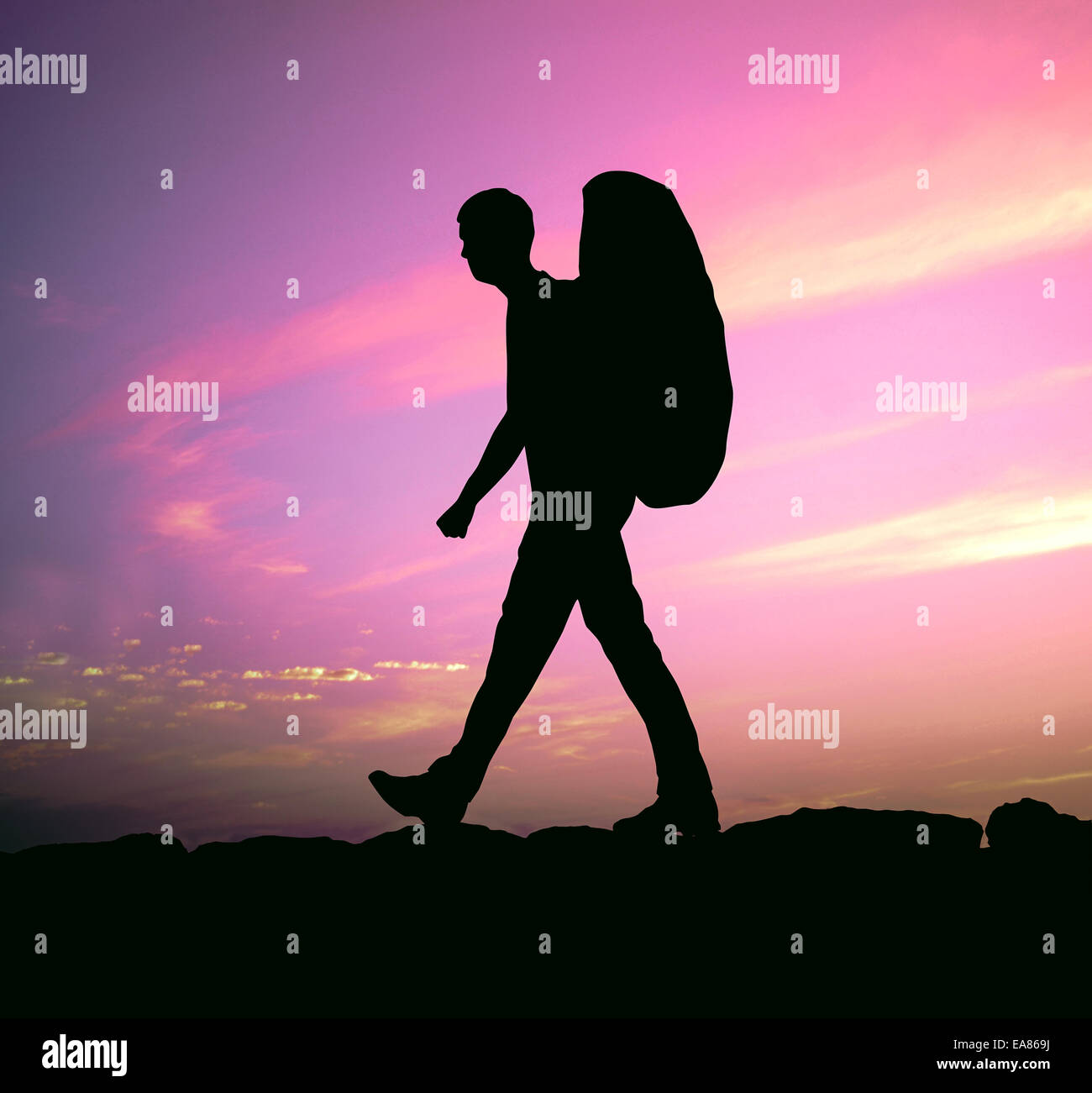 Escursionista con zaino contro un tramonto viola Foto Stock