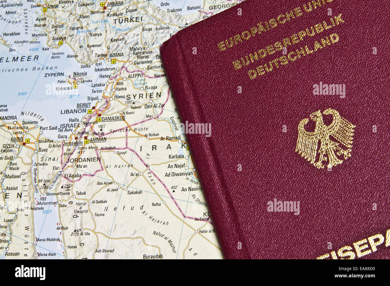 Close-up di un passaporto tedesco con una mappa del Medio Oriente in background Foto Stock