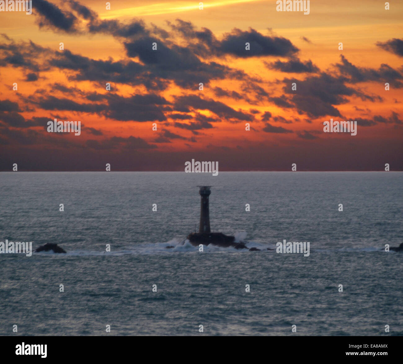 Tramonto spettacolare sopra il faro Longships Lands End Penwith West Cornwall South West England Regno Unito Foto Stock