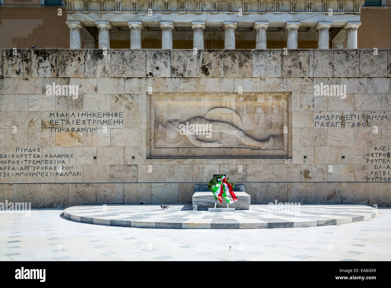 Un wreathe e fiori presso la tomba del Soldato sconosciuto a livello nazionale gli edifici del Parlamento a Atene, Grecia, Euyrope. Foto Stock