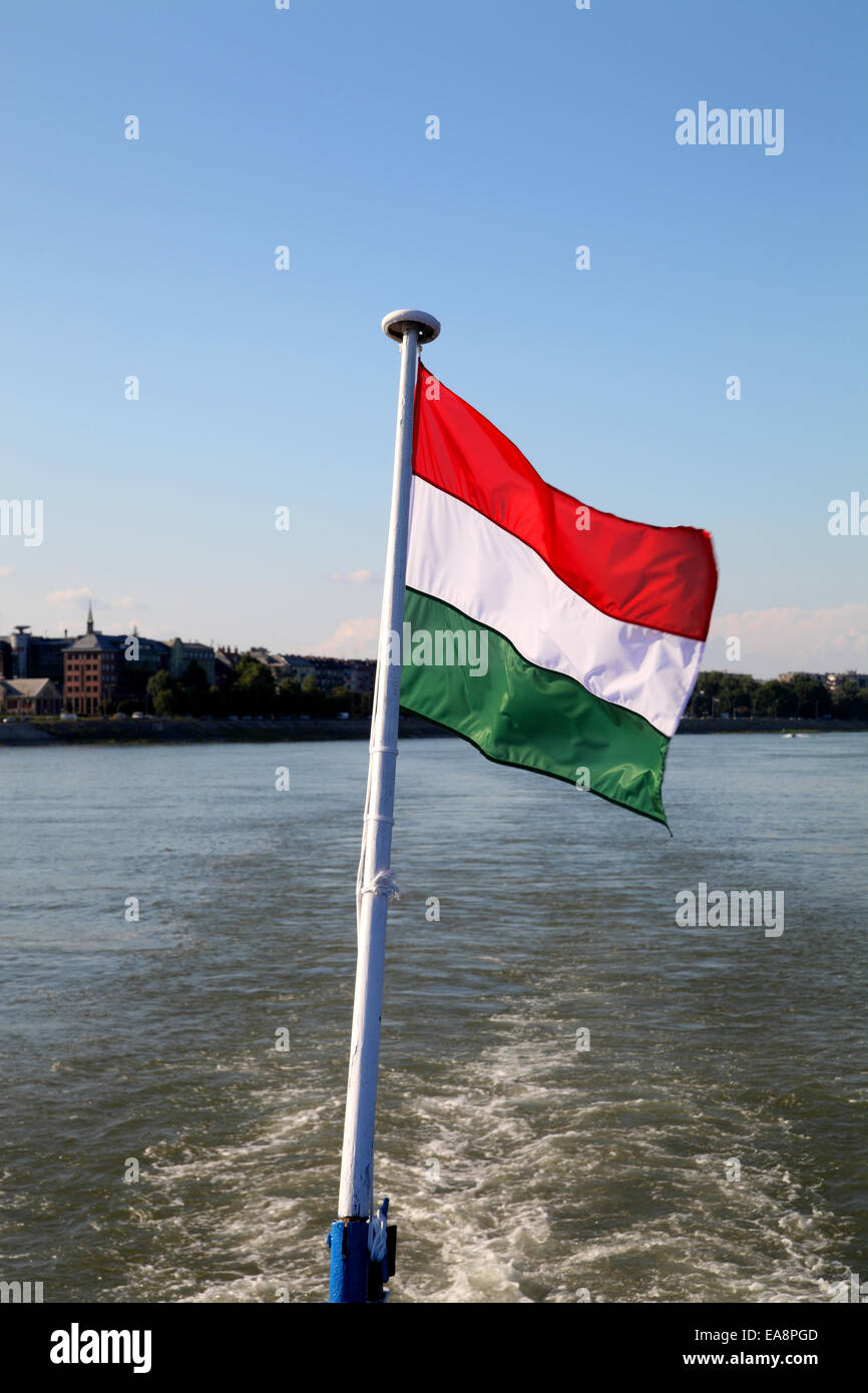 Bandiera ungherese contro un cielo blu volato dalla parte posteriore della nave da crociera sul Danubio vicino a Budapest Ungheria Foto Stock