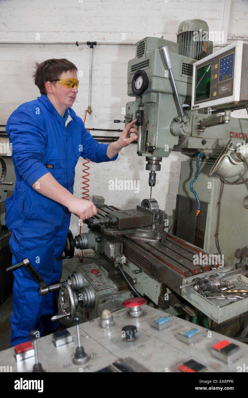 Tecnico su una macchina perforatrice strumento utilizzato nella fabbricazione di componenti idraulici Foto Stock