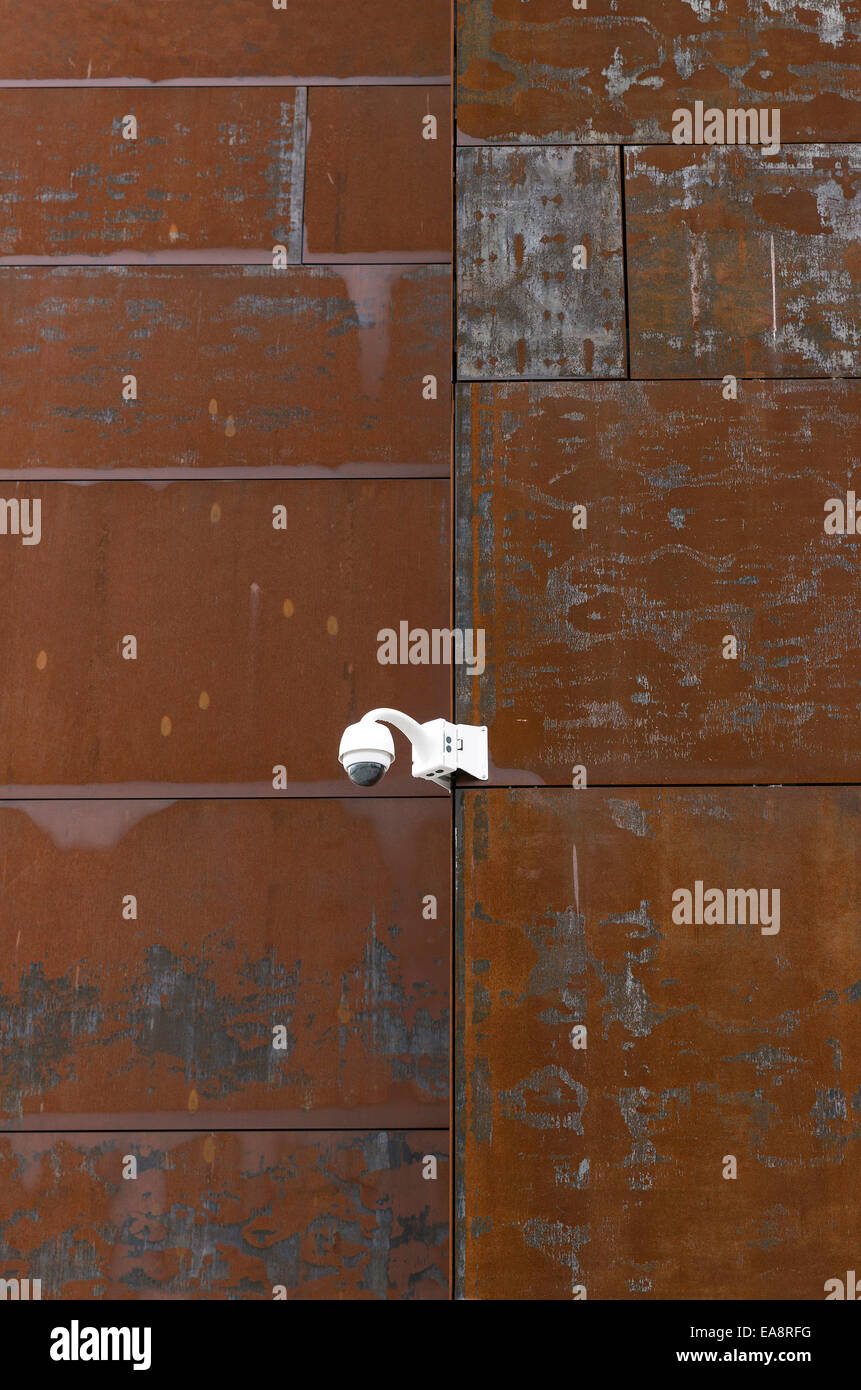 Telecamera di sorveglianza su una parete di metallo rosso Foto Stock