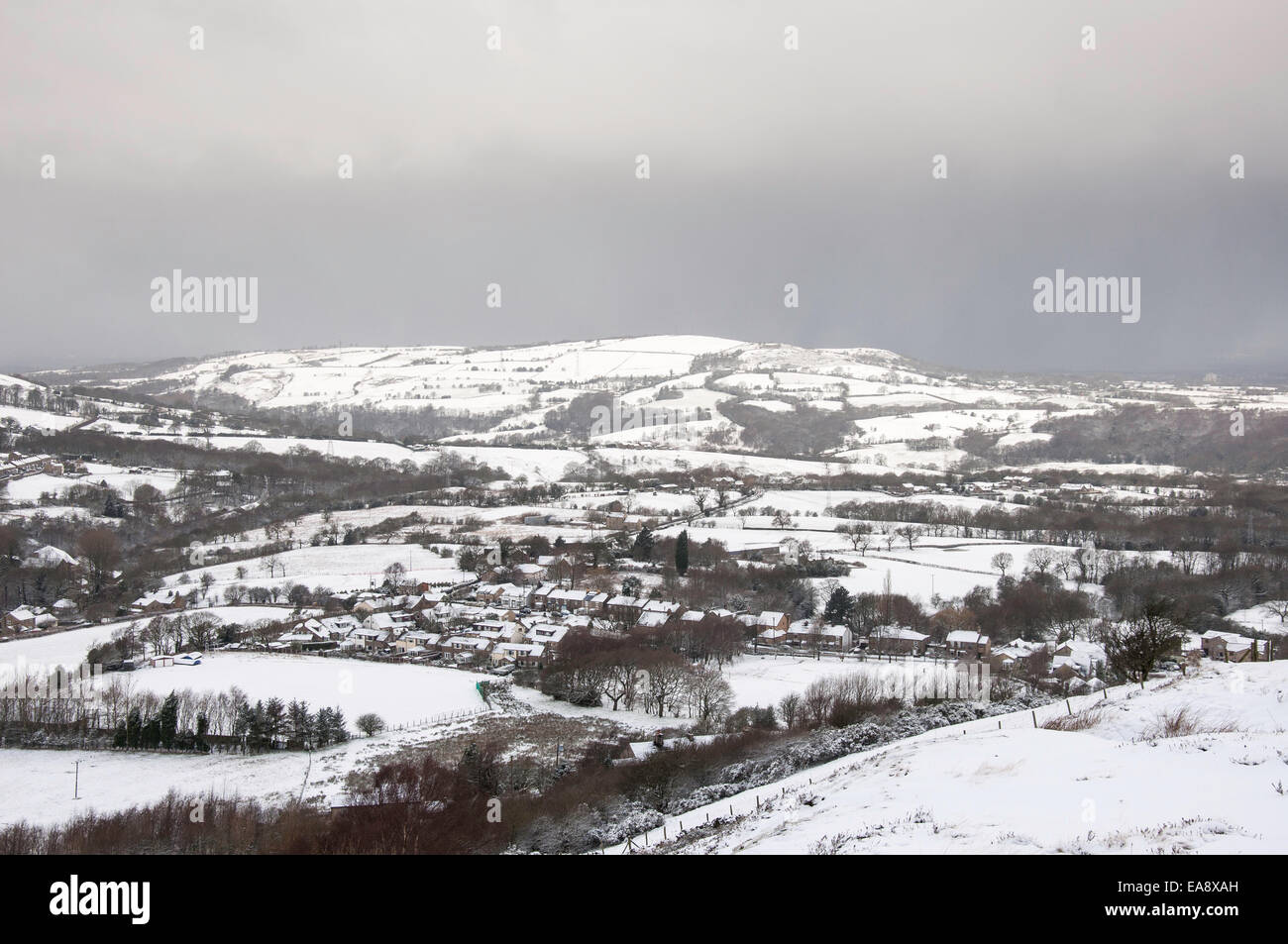 Villaggio di Charlesworth nella neve con neve scure nuvole cuscinetto pronto a dare un altro rivestimento. Foto Stock