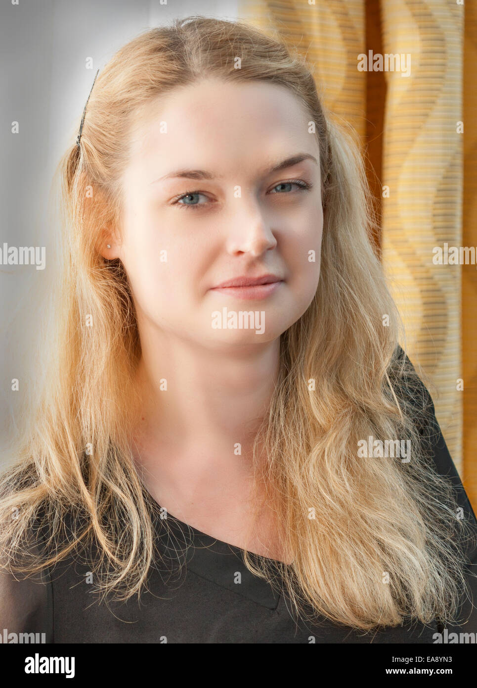 Giovani attraenti lunghi capelli biondi donna che guarda la fotocamera closeup Foto Stock