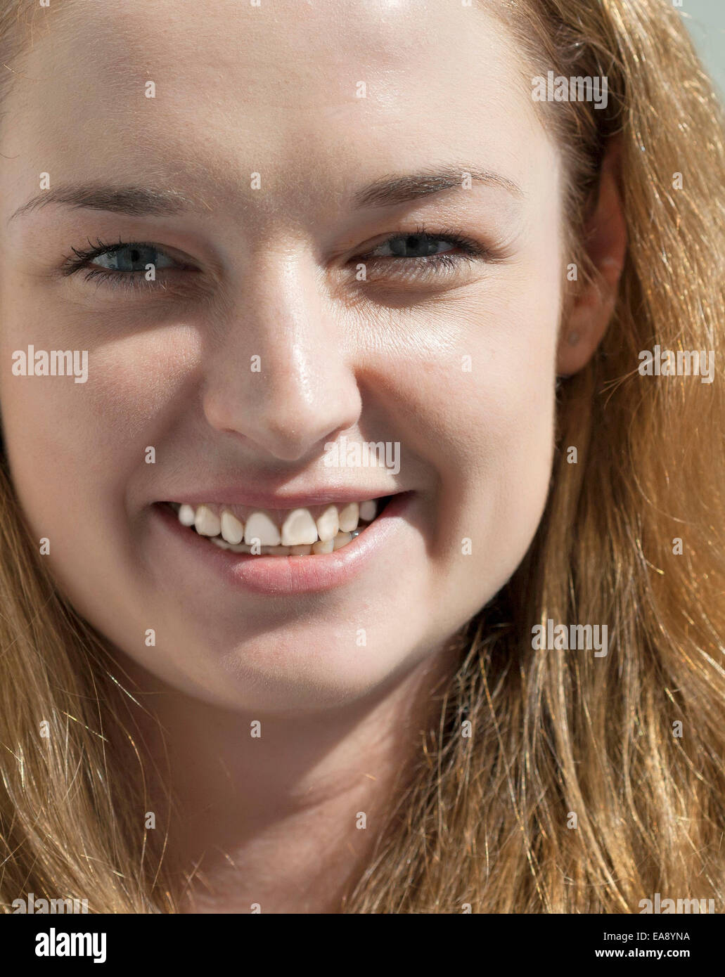 Giovani attraenti lunghi capelli biondi donna che guarda la fotocamera closeup Foto Stock