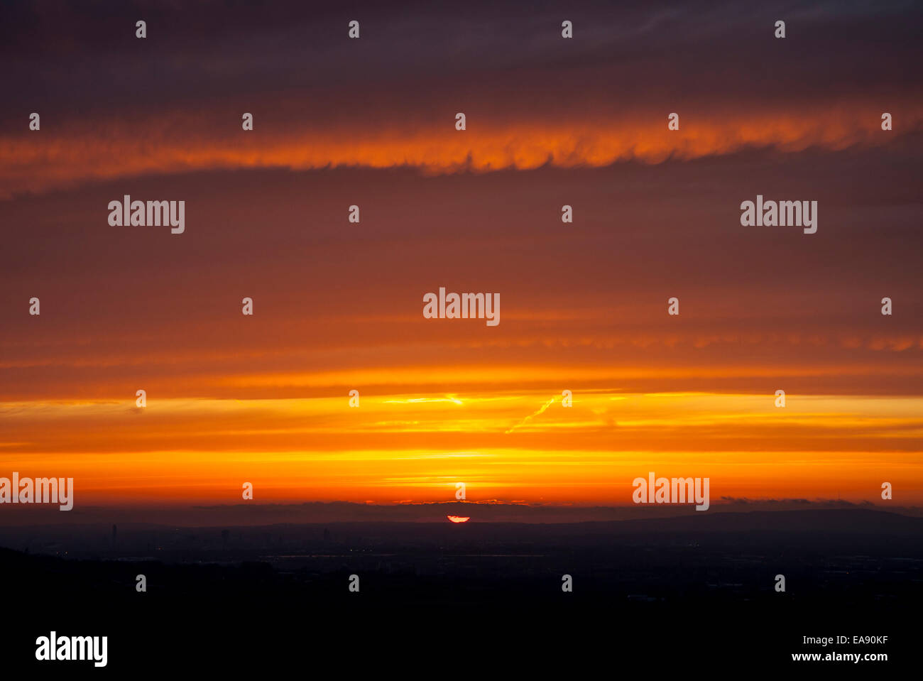 E drammatico tramonto colorato come si vede dalle colline vicino a Glossop guardando verso Manchester. Foto Stock