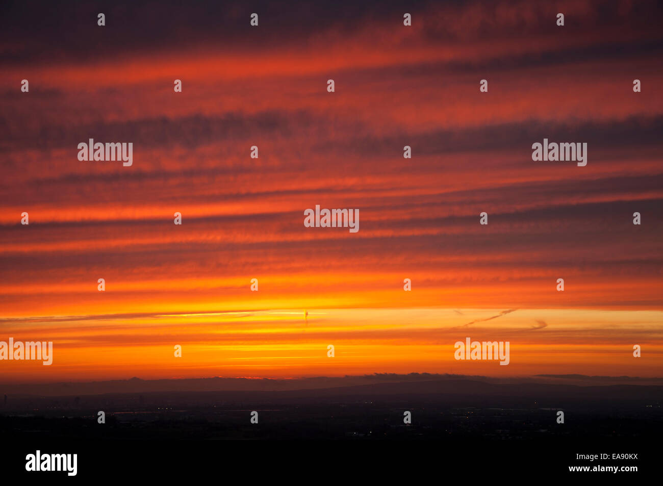E drammatico tramonto colorato come si vede dalle colline vicino a Glossop guardando verso Manchester. Foto Stock
