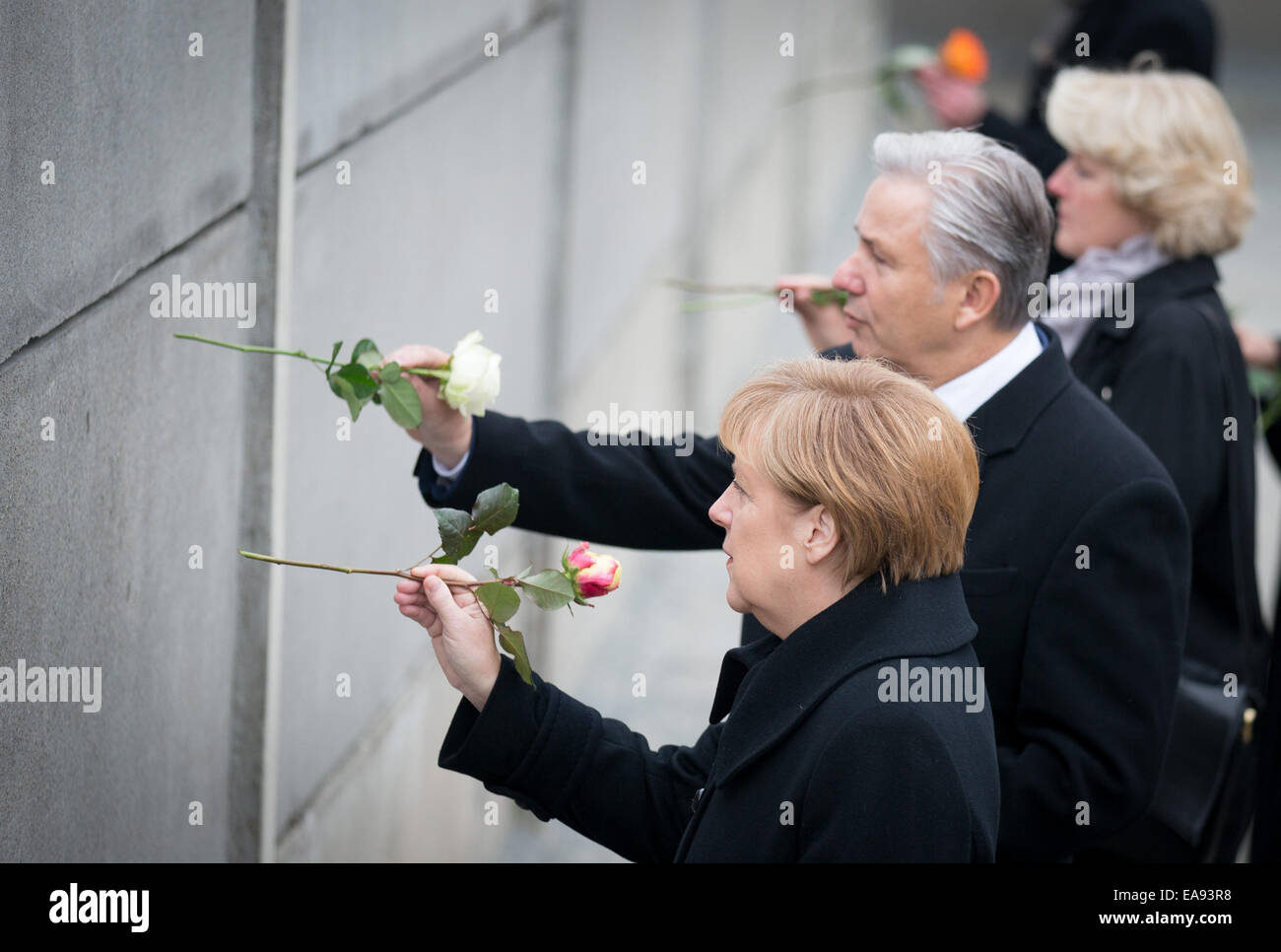 Berlino, Germania. 9 Nov, 2014. Il cancelliere tedesco Angela Merkel (CDU, anteriore), di Berlino che disciplinano il sindaco Klaus Wowereit (SPD) e il ministro di Stato per la cultura e i media, Monika Gruetters (CDU) luogo fiori in lacune del Memoriale del Muro di Berlino a Berlino (Germania), 9 novembre 2014. Numerose manifestazioni si svolgono per commemorare il venticinquesimo anniversario della caduta del muro di Berlino. Foto: Kay Nietfeld/dpa/Alamy Live News Foto Stock