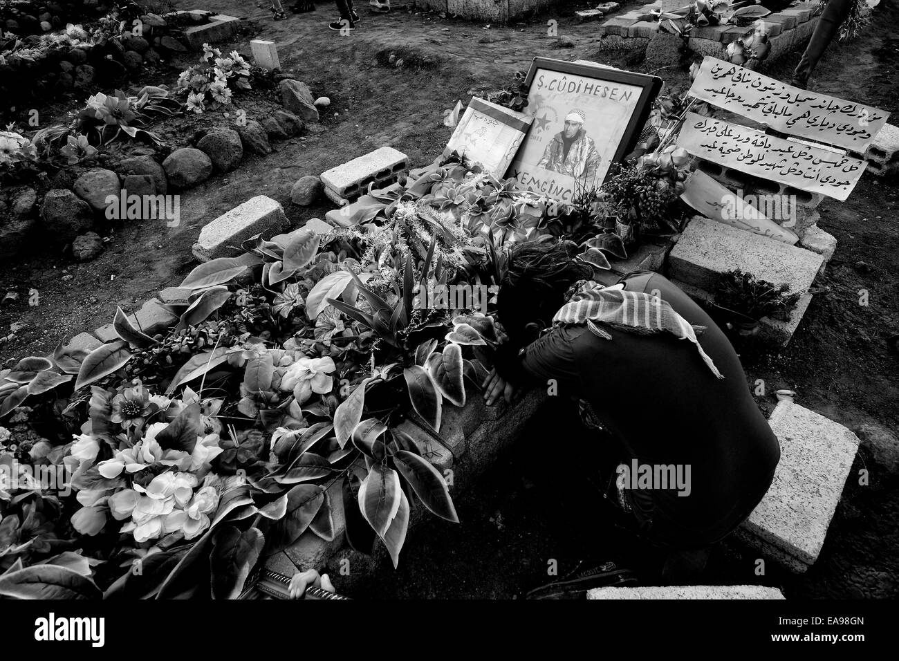 Mourner dolore sopra la tomba di un combattente di curdi uccisi da uno Stato islamico ISIS o ISIL militanti in un cimitero vicino la città di Al-Malikiyah anche chiamato Derek ( ) curda in Al Hasakah o distretto Hassakeh nella Siria settentrionale Foto Stock