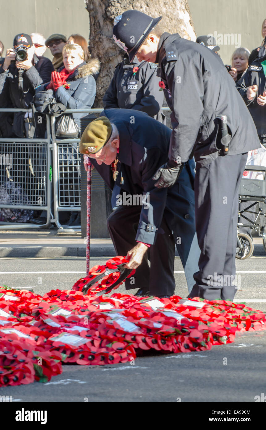 Un soldato anziani assistiti da un poliziotto presso il Cenotafio pone una corona di fiori durante l annuale del Servizio Nazionale di ricordo presso 11:00 sul ricordo domenica Foto Stock