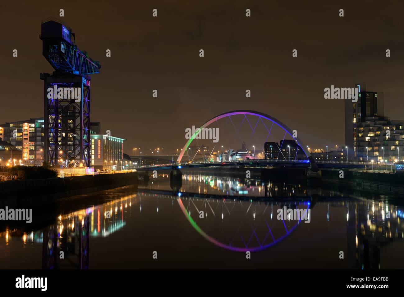 Il fiume Clyde a Glasgow con l'Arco (ponte di squinty) e gru illuminate per celebrare il MTV EMA all'arena SSE Hydro Foto Stock