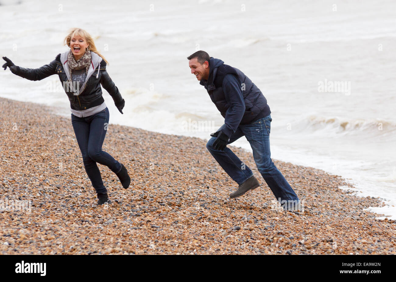 Un giovane godendo una giornata nella località balneare inglese a Brighton in caldo abbigliamento invernale Foto Stock