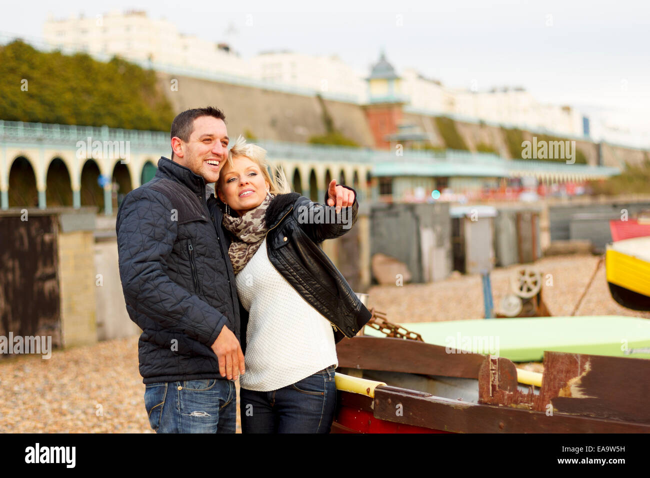Un giovane godendo una giornata nella località balneare inglese a Brighton in caldo abbigliamento invernale Foto Stock