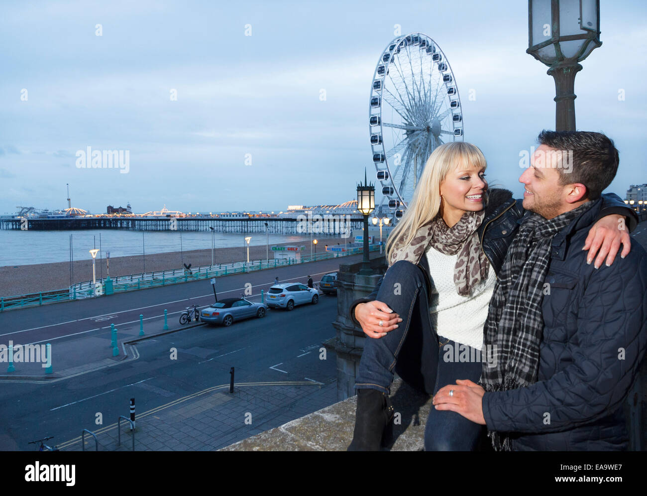Un giovane godendo una giornata nella località balneare inglese a Brighton in caldo abbigliamento invernale Foto Stock