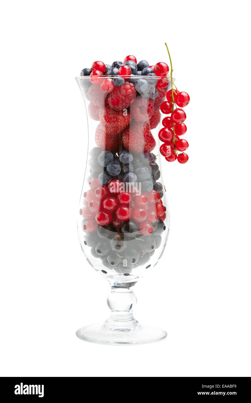 Dolce di frutti di bosco freschi (lamponi, fragole, mirtilli e ribes rossi) nel bicchiere da cocktail, isolato Foto Stock