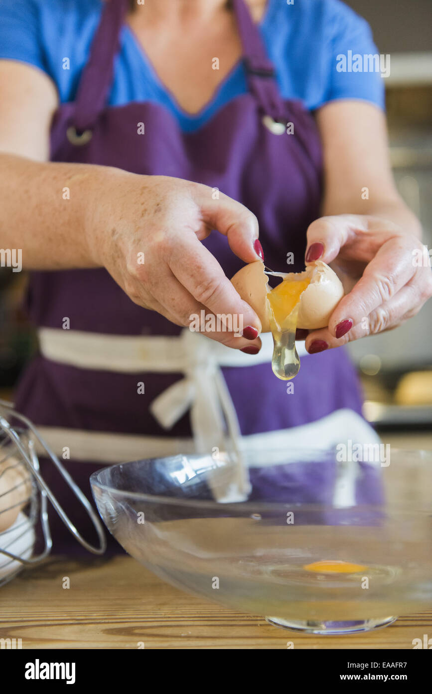 Una donna a un tavolo da cucina fata di cottura per torte. Foto Stock