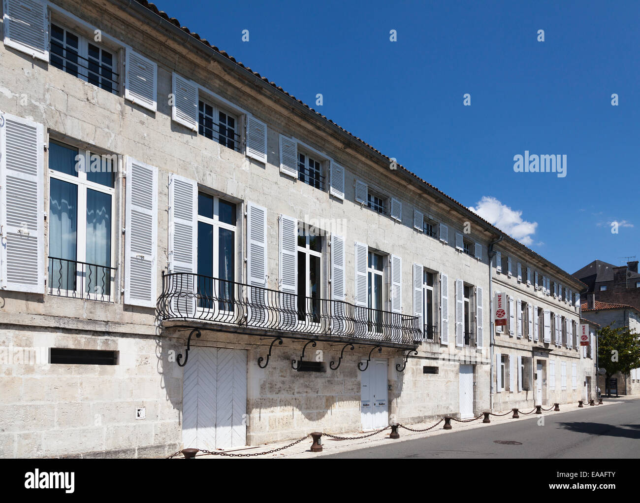 Esterno della classica francese case con alte finestre e persiane bianche sul Quai de l'orangerie Jarnac Foto Stock
