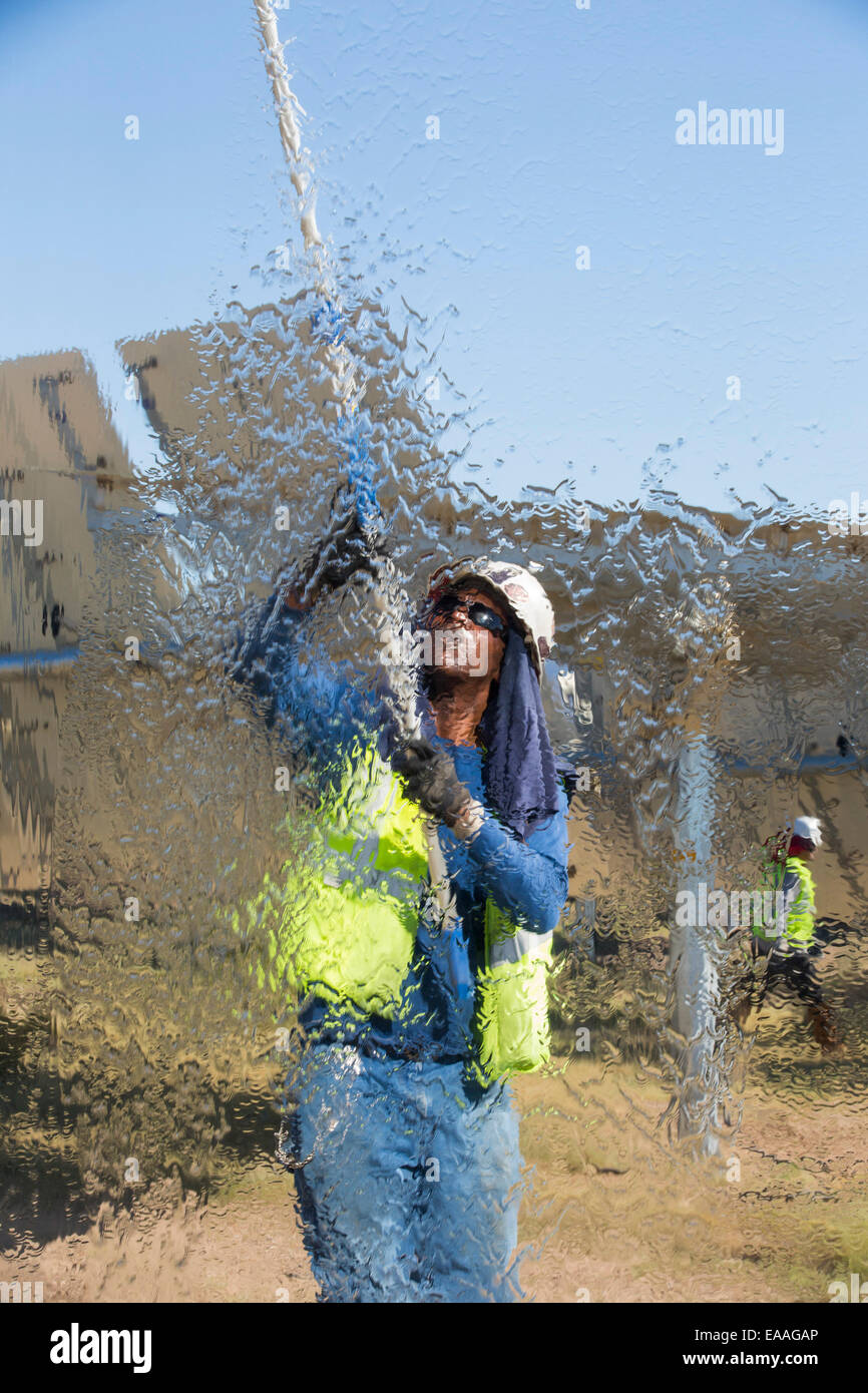 Lavoratori il lavaggio del heliostats per massimizzare il potere riflettente al Ivanpah Solar Thermal Power Plant in California''s Deserto Mojave è attualmente il più grande impianto solare termico nel mondo. Esso genera 392 megawatt (MW) e distribuisce 173,500 heliostats che riflettono i raggi suns su tre torri solare. Esso copre 4.000 acri di deserto. Foto Stock