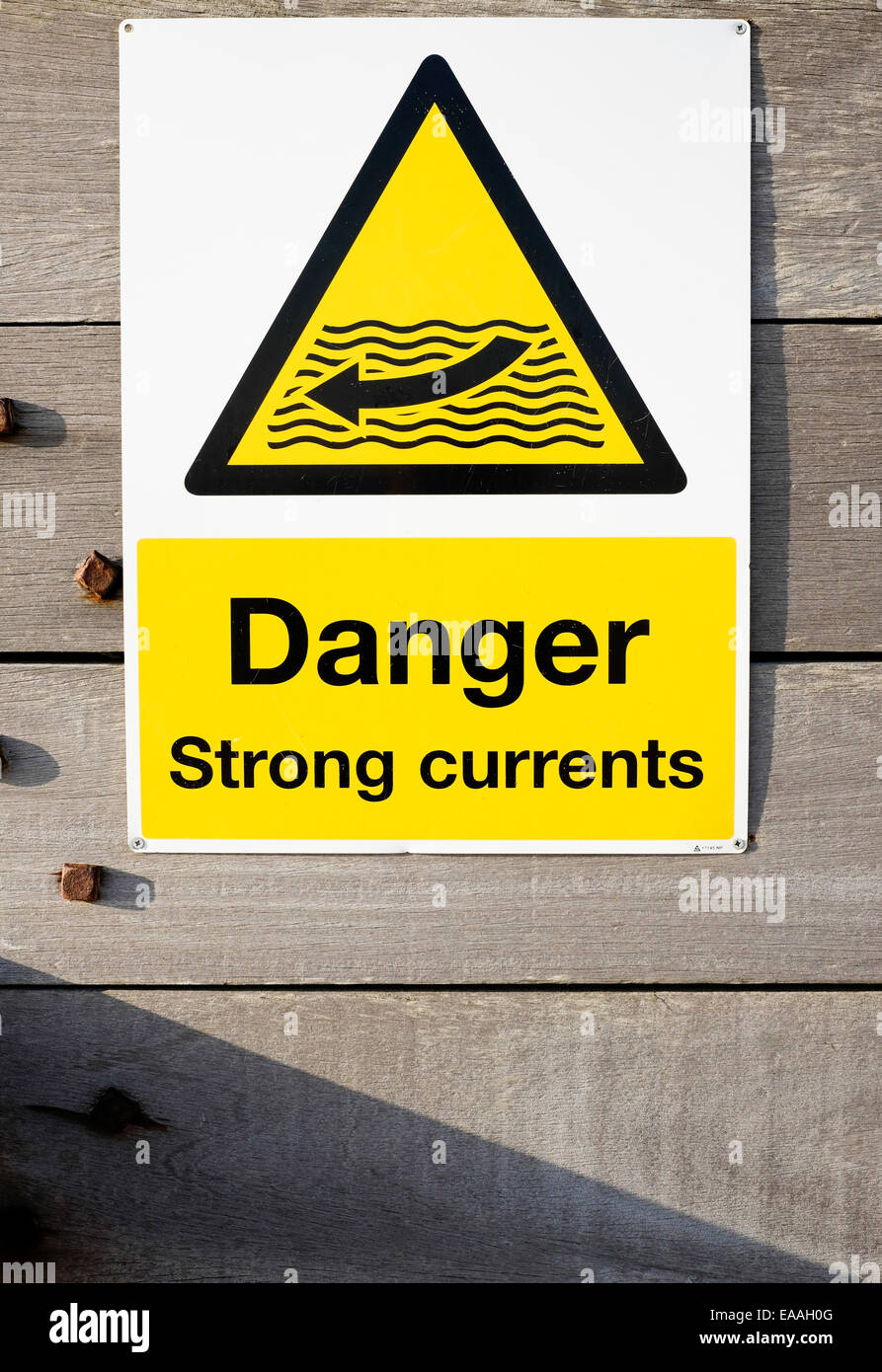 Inghilterra, Sussex, West Wittering. Montato segno potenziale avvertimento nuotatori di forti correnti in mare. Foto Stock