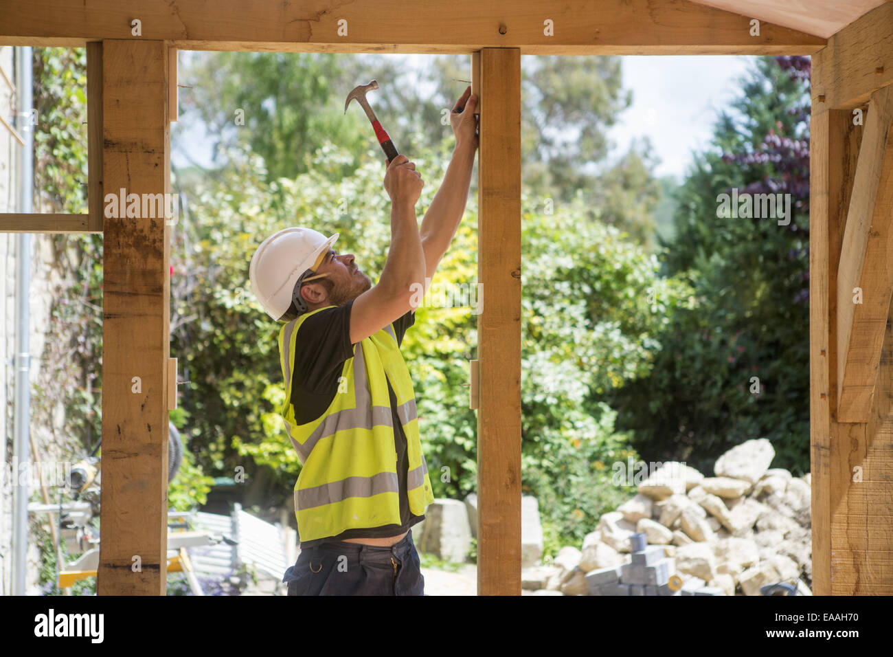 Un lavoratore edile indossando alta visibilità giubbotto di sicurezza e casco. Foto Stock