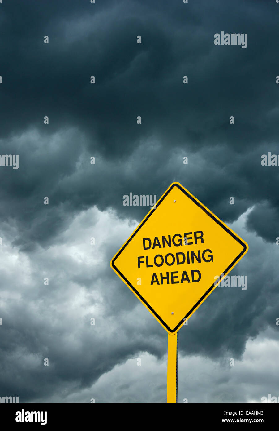 Inondazioni in anticipo cartello stradale: un segno di attenzione nella parte anteriore delle nubi di avvertimento "pericolo inondazioni a venire". Foto Stock