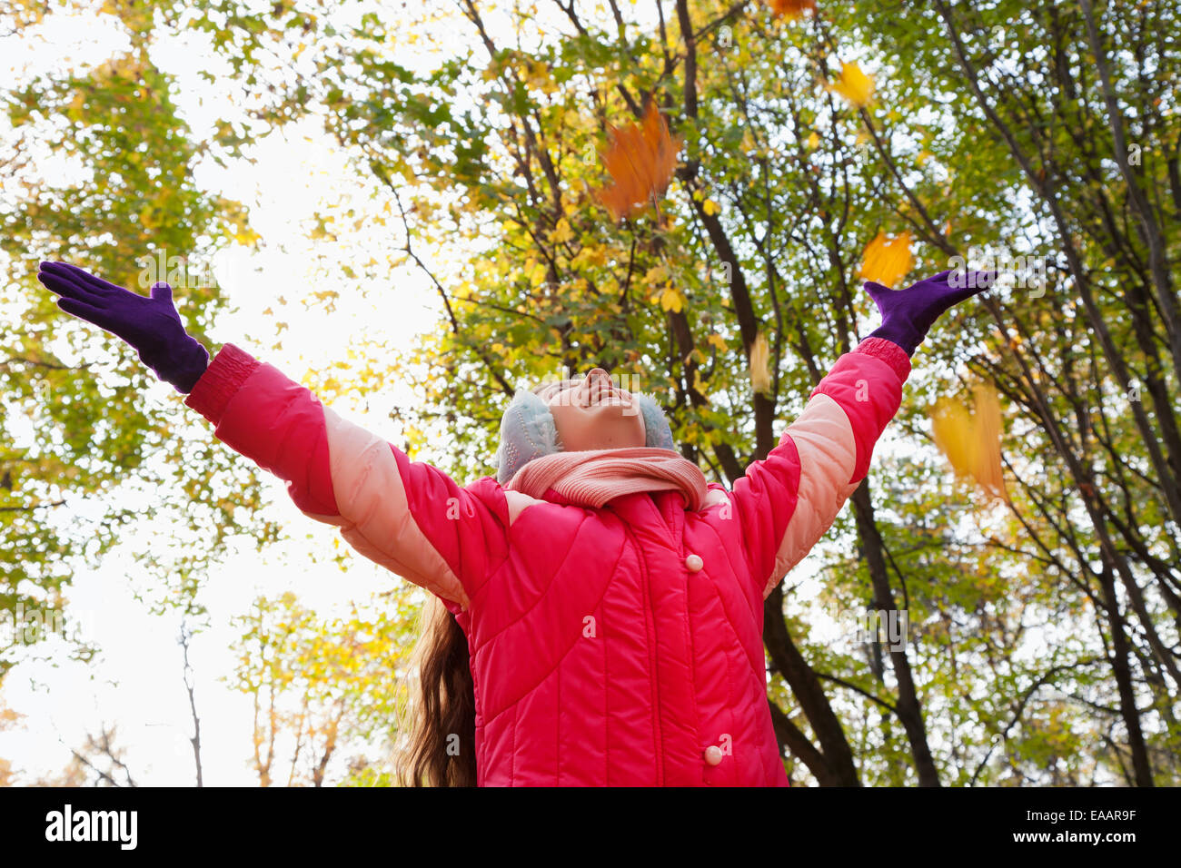 Ragazza con grande piacere dalla caduta di foglie di acero in autunno park Foto Stock