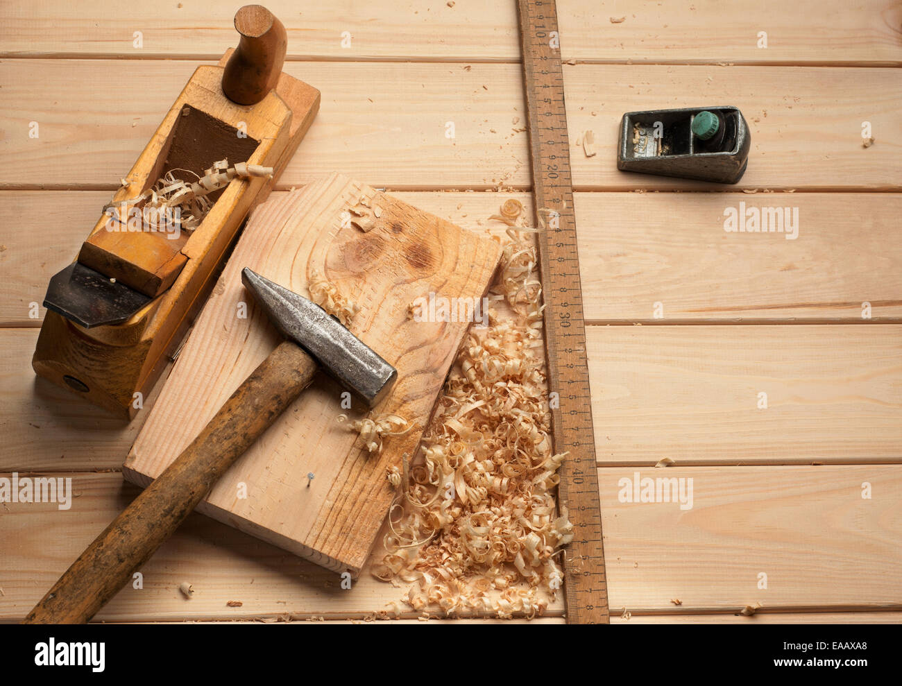 Falegname attrezzi,martello,metro, unghie, trucioli e piano su tavola di legno Foto Stock