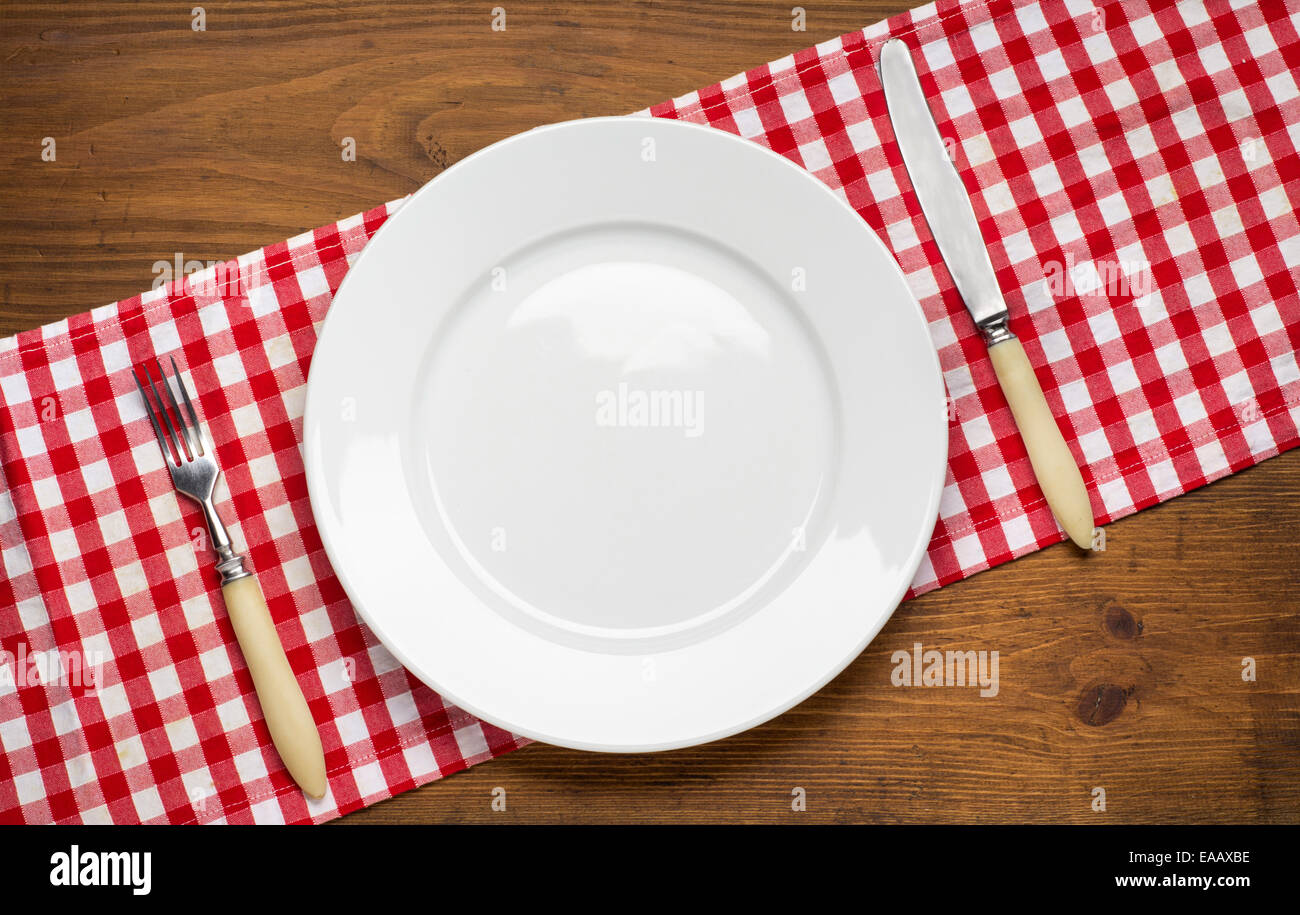 Piastra vuota con la forchetta e coltello su un tavolo di legno. Foto Stock