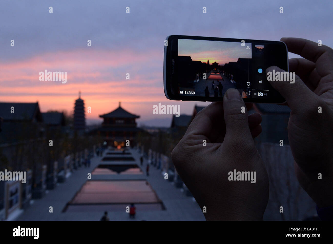 Pechino, Cina. Xi Nov, 2014. Un giornalista prende le foto del tramonto a Yanqi lago dove il ventiduesimo APEC leader economici" si è riunito a Huairou distretto di Pechino, capitale della Cina, nov. 11, 2014. Credito: Wu Wei/Xinhua/Alamy Live News Foto Stock