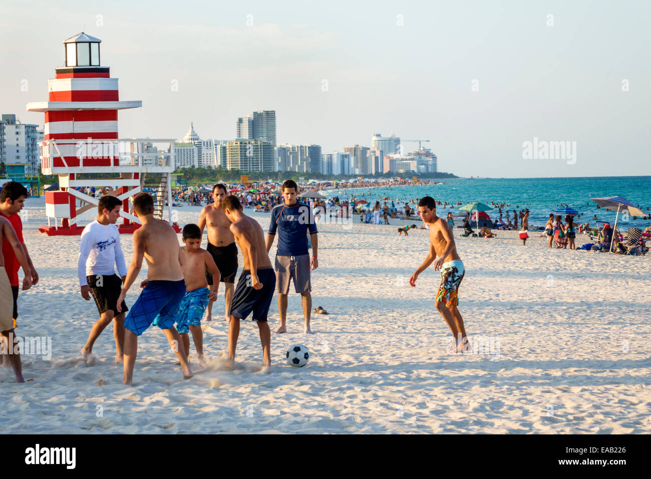 Miami Beach Florida,sabbia,stazione di bagnino a forma di faro,Oceano Atlantico,acqua,sabbia,uomo ispanico maschio,teen teen teen ager ragazzo giocare Foto Stock