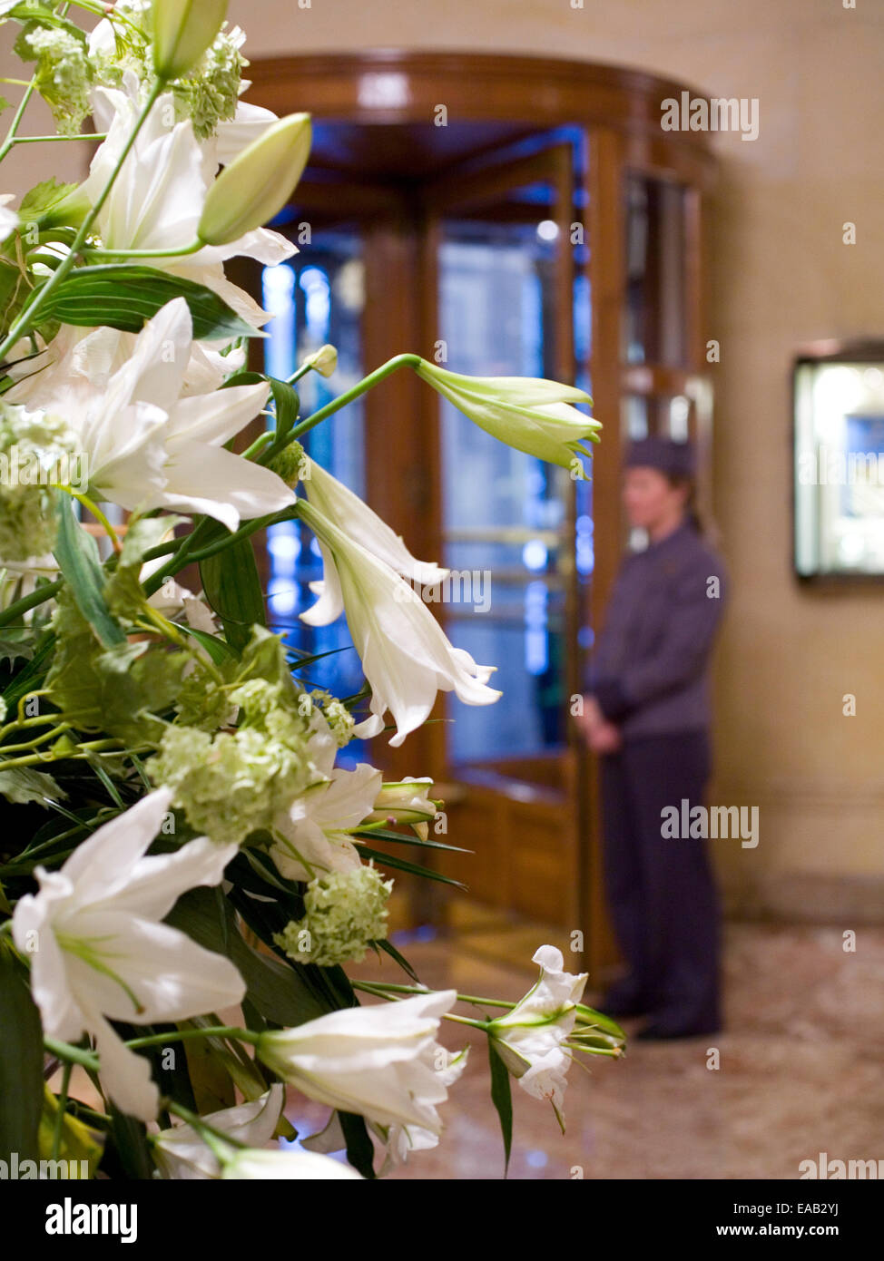 Gigli bianchi e la lobby dell'hotel con tradizionali bell hop Foto Stock