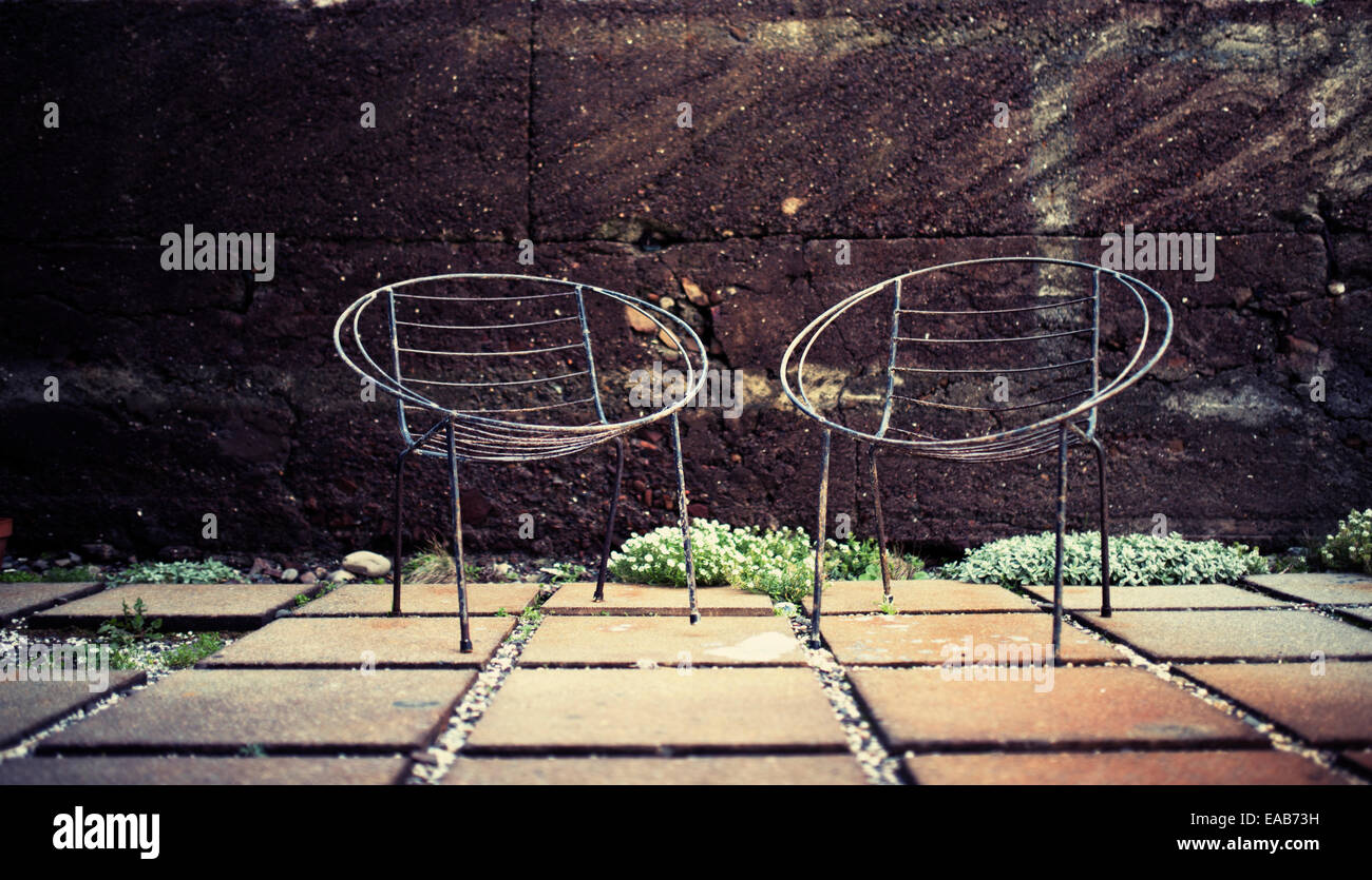 Due sedie patio senza cuscini con cornice in acciaio Foto Stock