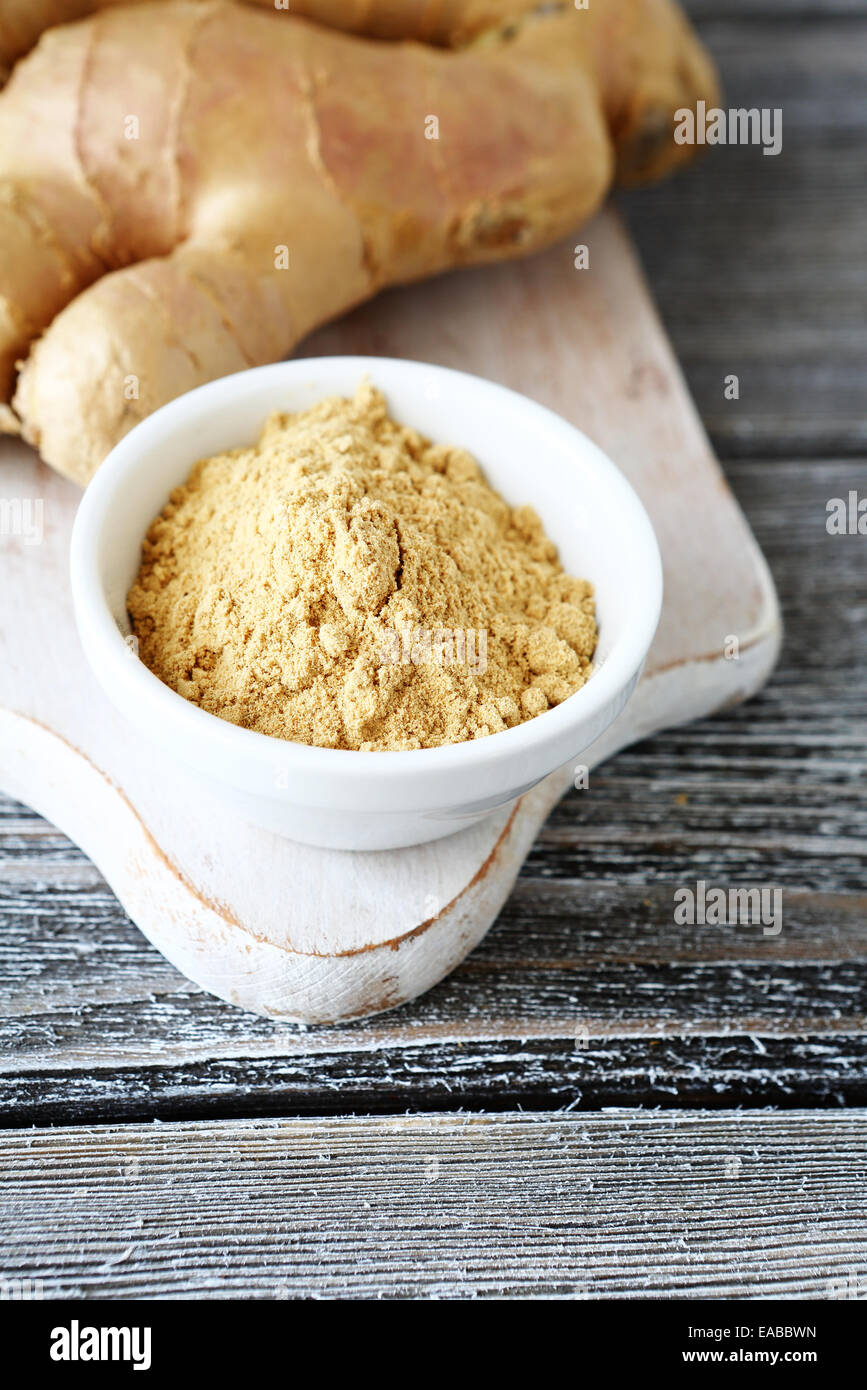 Di zenzero fresco con polvere su di un tagliere e speziato Foto Stock