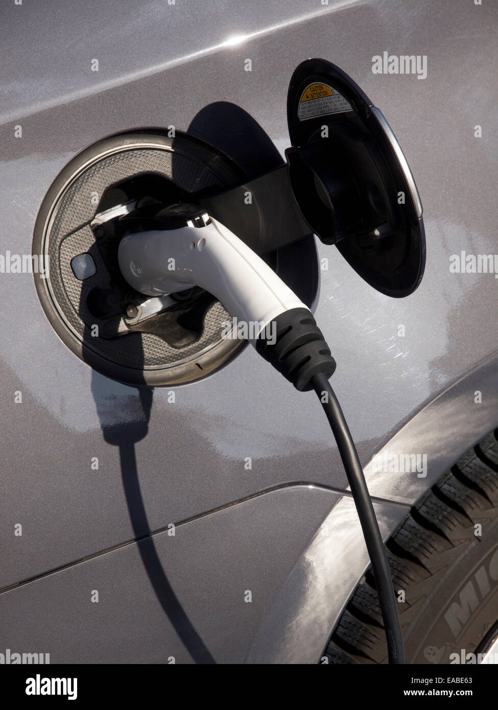 Hybrid auto elettrica con elettricità cavo di ricarica close up di spina e presa Foto Stock
