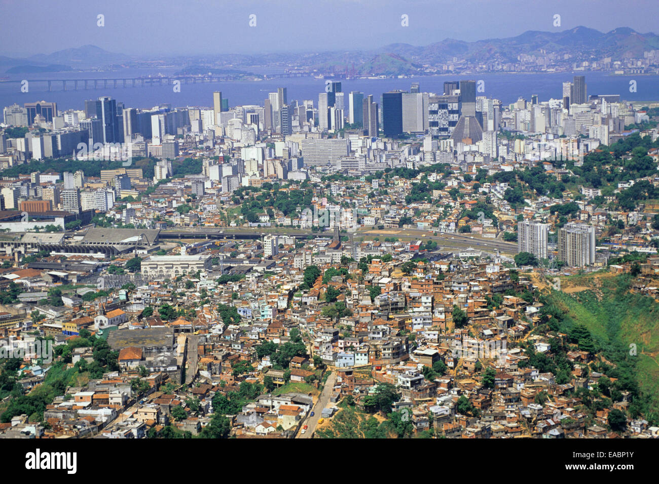 Rio de Janeiro, Brasile. Favela Dona Marta; bordi della baraccopoli con Sambadrome, downtown area e Niteroi Bridge. Foto Stock