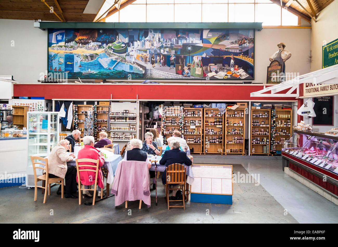 I turisti anziani si godono una pausa ristoratrice nel mercato al coperto In Tenby Galles del Sud Regno Unito Foto Stock