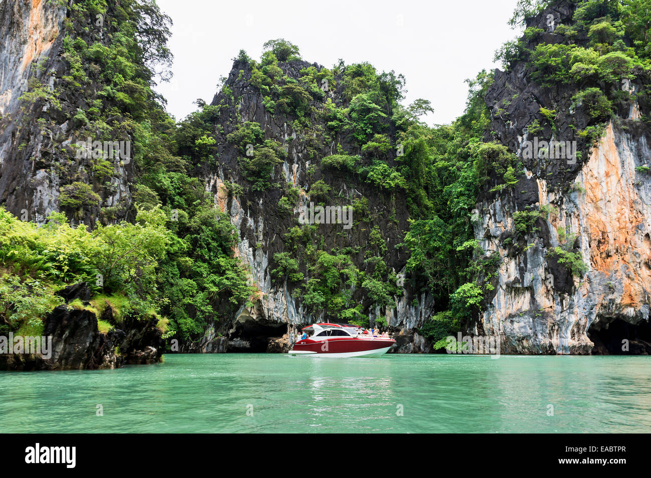 Thailandia Koh Phanak vista di yacht a motore nella parte anteriore delle ripide rocce a Phang Nga Bay Foto Stock