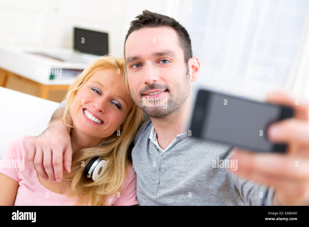 Vista di una giovane coppia attraente divertirsi facendo selfie Foto Stock