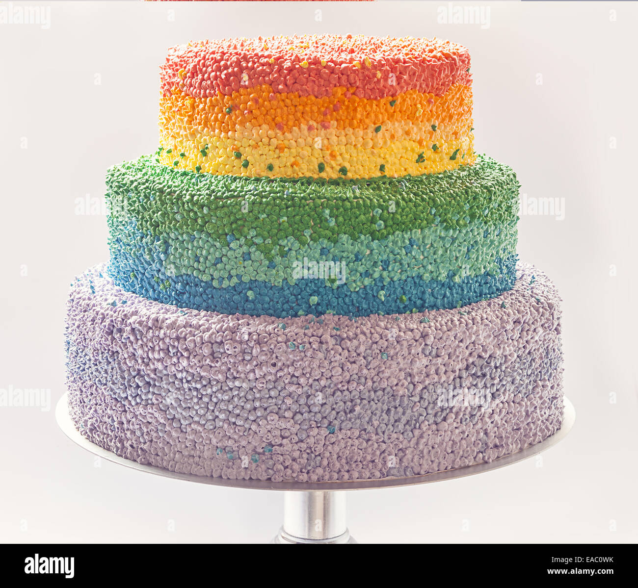Dettagli di una torta di compleanno decorata con crema nei colori dell'arcobaleno. Foto Stock