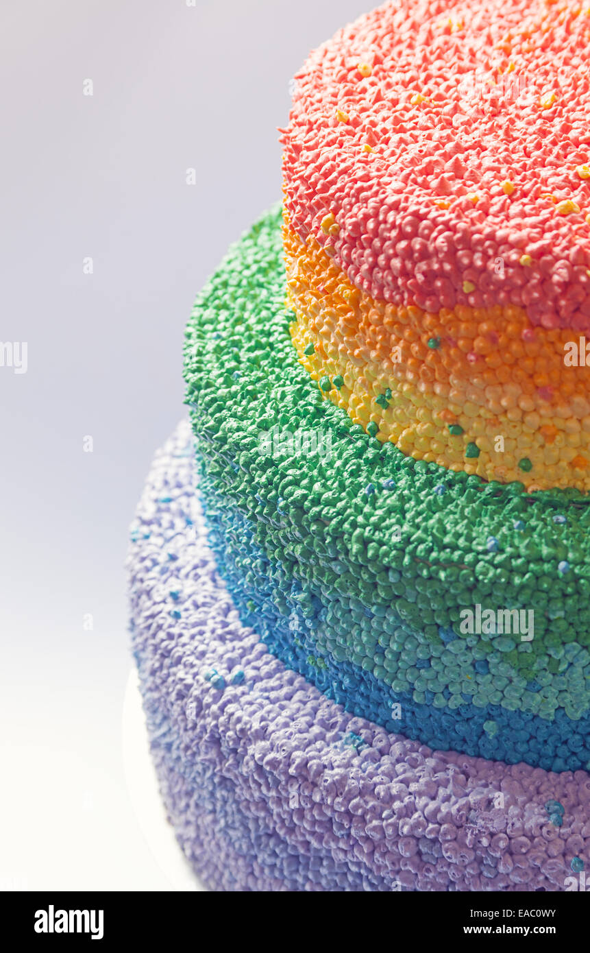 Dettagli di una torta di compleanno decorata con crema nei colori dell'arcobaleno. Foto Stock