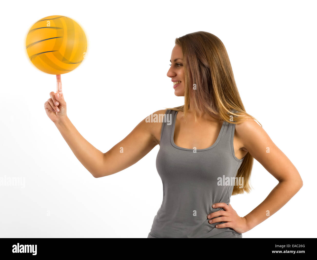 Giovane donna in piedi lateralmente il bilanciamento di una sfera Foto Stock