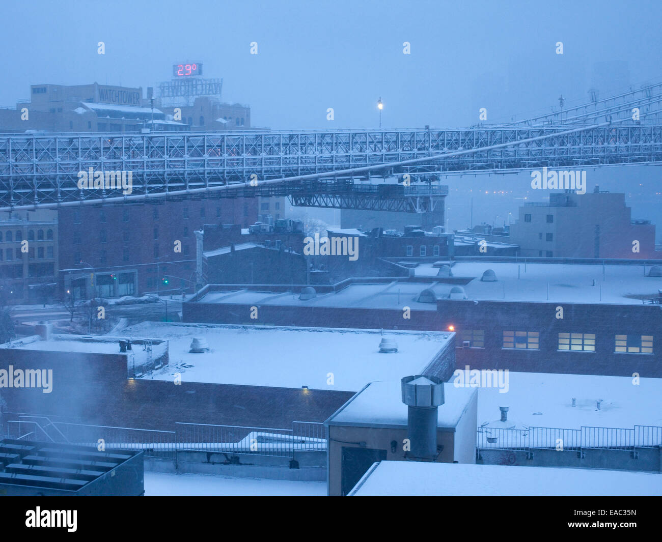 Paesaggio urbano con tetti e Ponte di Brooklyn carreggiata la mattina di una tempesta di neve. Foto Stock