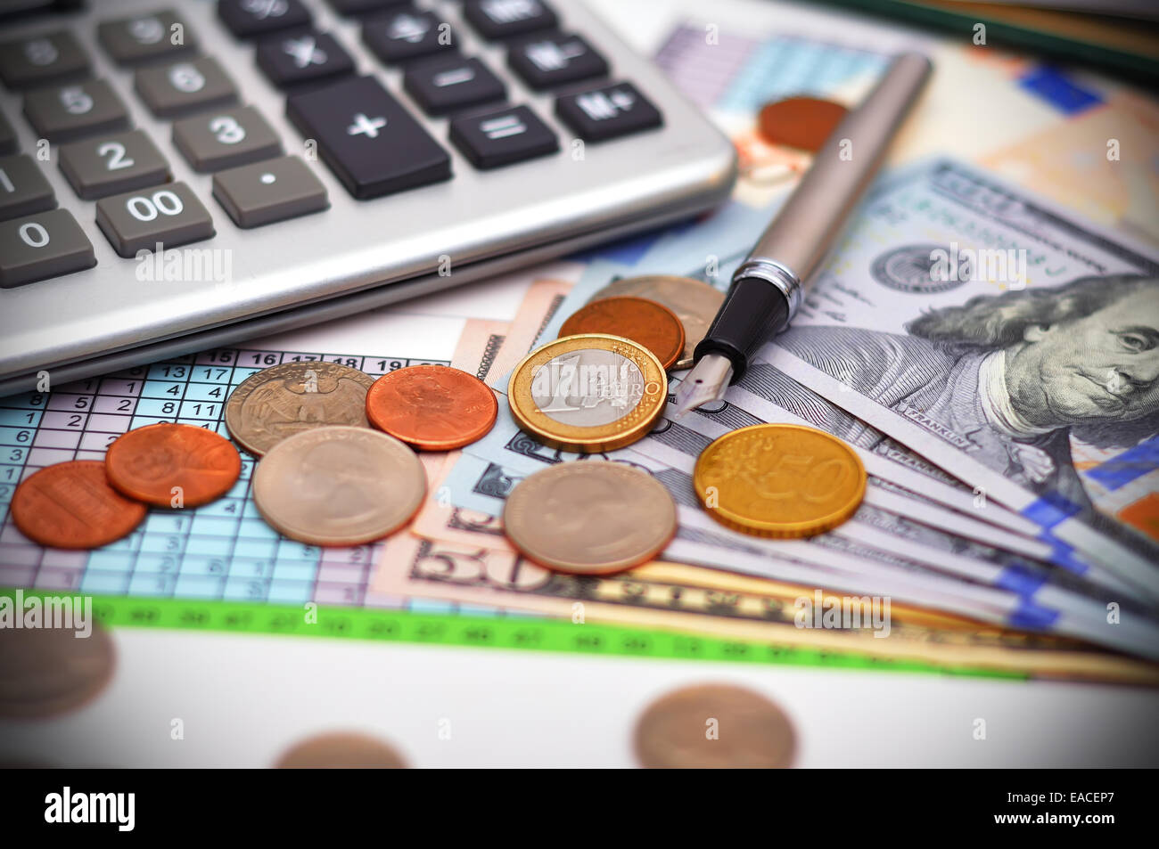Monete in euro con penna e calcolatrice sul tavolo Foto Stock