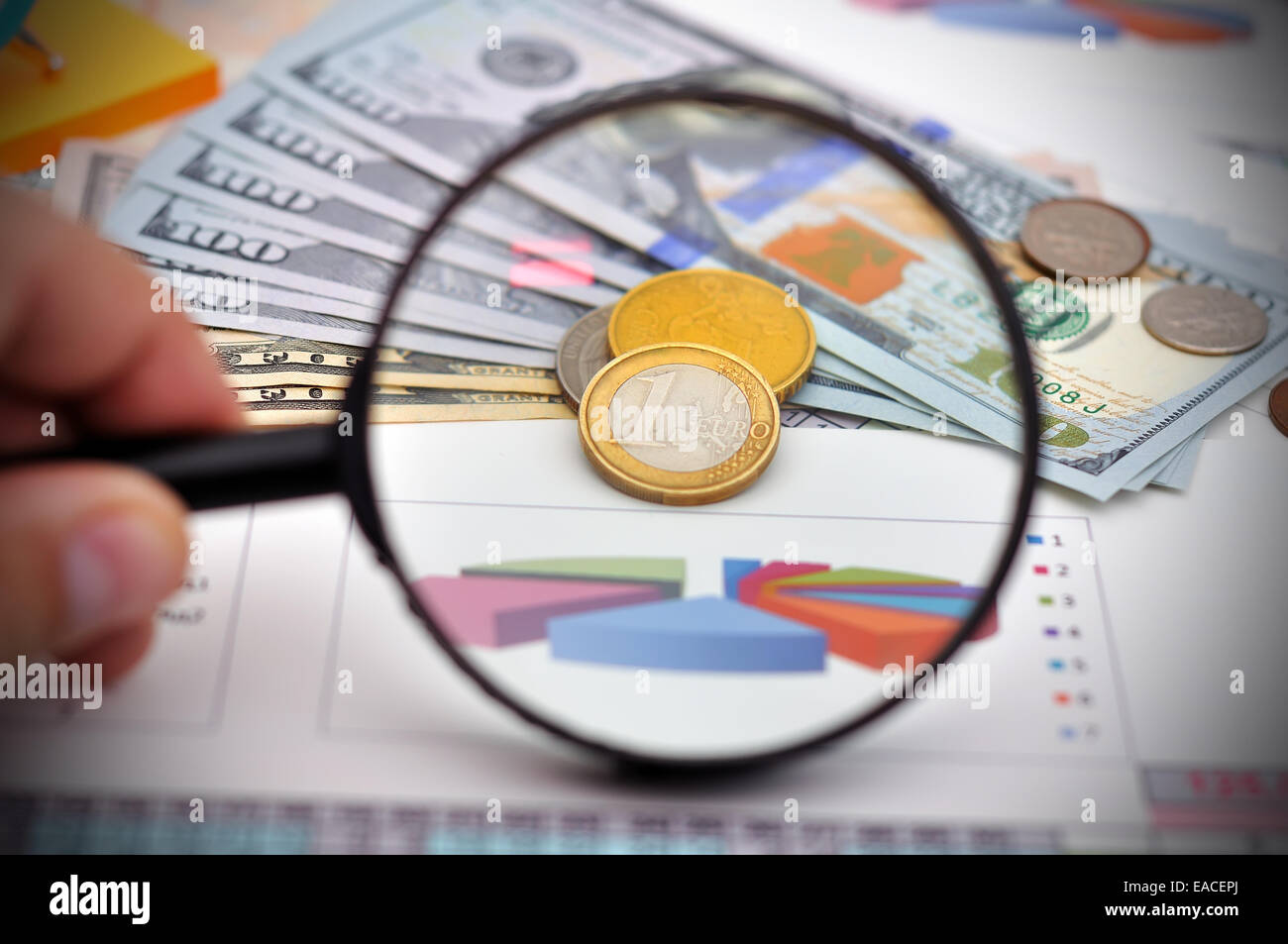 Studio delle monete metalliche in euro con una lente di ingrandimento Foto Stock