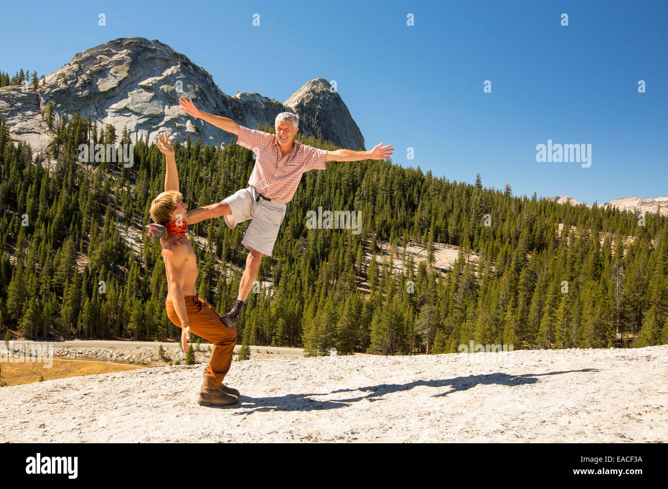 Nicholas Coolridge esegue un equilibrio spostare con il cambiamento climatico fotografo, Ashley Cooper su una cupola di granito in Yosemite National Park, California, Stati Uniti d'America. Foto Stock
